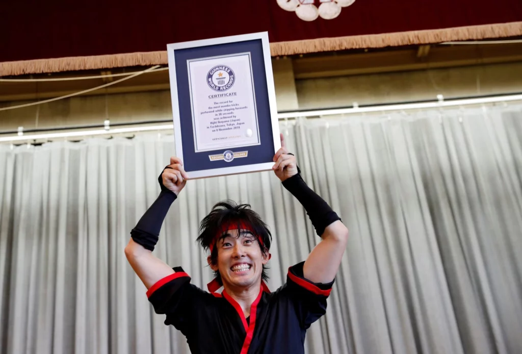 Hijiki Ikuyama gagne le record de monde de saut à la corde à une jambe. Gagnant tient son trophée. Guinness Book record cadre.