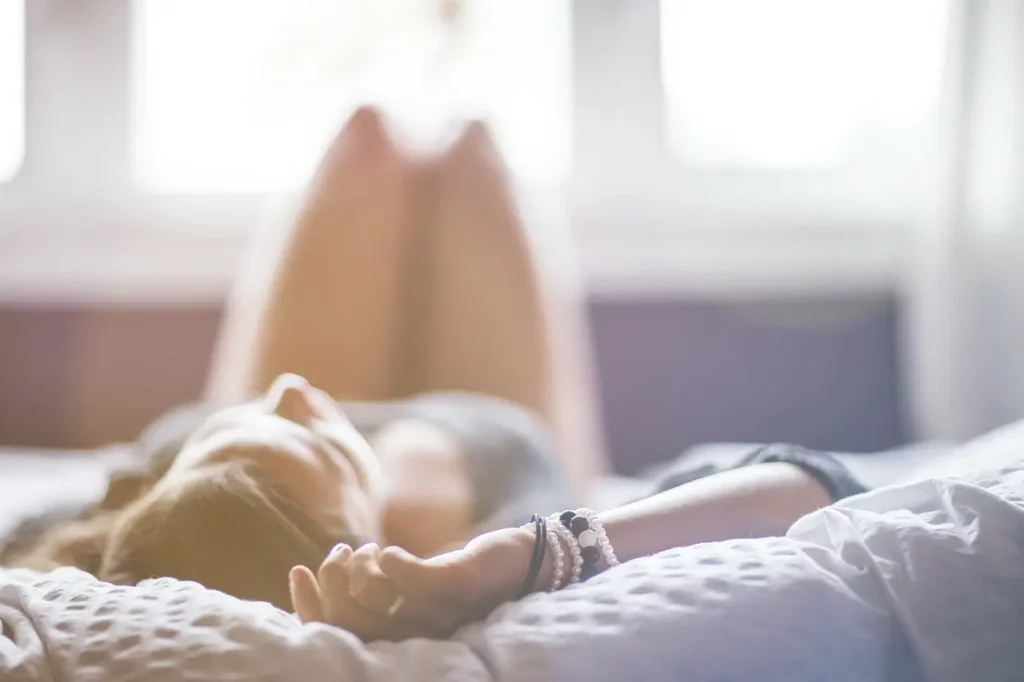 Jeune femme allongé sur un lit après le plus grand gang-bang du monde.